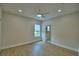 Neutral bedroom with light wood floors, ceiling fan, and a view of the yard from the window at 2673 Calistoga Ave, Kissimmee, FL 34741