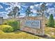 Stone sign for Sonoma Resort, a park square community, set amongst green shrubbery and a bright blue sky at 2673 Calistoga Ave, Kissimmee, FL 34741