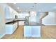 Well-lit kitchen with stainless steel appliances, white cabinets, dark countertops, and an island with pendant lights at 2673 Calistoga Ave, Kissimmee, FL 34741