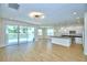 Bright, open-concept living area featuring wood floors, modern lighting and sliding glass doors to a private pool at 2673 Calistoga Ave, Kissimmee, FL 34741