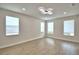 Spacious living room with wood-look floors, three large windows, and neutral walls at 2673 Calistoga Ave, Kissimmee, FL 34741