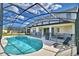 Screened-in pool with lounge chairs, patio area, and -safety fencing at 2673 Calistoga Ave, Kissimmee, FL 34741