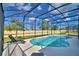 Kidney-shaped pool enclosed with black safety fencing, lounge chairs, and yard views at 2673 Calistoga Ave, Kissimmee, FL 34741