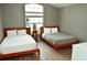 Light-filled bedroom showcasing two beds, wood-look floors, and a large window at 2807 Playing Otter Ct, Kissimmee, FL 34747