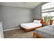 Bright bedroom featuring two beds, wood-look floors, a high ceiling, and a large window at 2807 Playing Otter Ct, Kissimmee, FL 34747