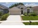 Inviting one-story home showcases a lush lawn, two-car garage, and lovely landscaping at 2807 Playing Otter Ct, Kissimmee, FL 34747
