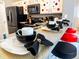 Kitchen bar features stylish place settings, black and red bar stools, and vibrant decor at 2807 Playing Otter Ct, Kissimmee, FL 34747
