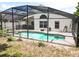Screened-in pool is surrounded by a concrete patio and lush landscaping, providing a private backyard oasis at 2807 Playing Otter Ct, Kissimmee, FL 34747