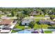 Aerial view of the blue home in a neighborhood with mature trees, and surrounding neighborhood streets at 2830 W Oak St, Kissimmee, FL 34741