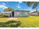 Exterior backyard with lawnmower, screen room, and a well-maintained lawn at 2830 W Oak St, Kissimmee, FL 34741
