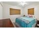 Serene bedroom featuring a blue comforter, a dark wood dresser, and soft window light at 2830 W Oak St, Kissimmee, FL 34741