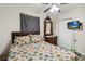Comfortable bedroom with a floral comforter, classic dresser, and a mounted TV for nighttime entertainment at 2830 W Oak St, Kissimmee, FL 34741