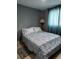 Bedroom features a queen size bed with pillows, patterned comforter, lamp, rug, and curtains at 2830 W Oak St, Kissimmee, FL 34741