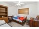 Bright bedroom with a twin bed, open bookshelf, desk, natural light from the window, and unique terrazzo flooring at 2830 W Oak St, Kissimmee, FL 34741