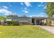 Welcoming single-story home with a covered front entrance, lush lawn, and blooming bushes at 2830 W Oak St, Kissimmee, FL 34741