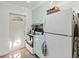 View of the kitchen with white appliances, light blue cabinets, and a sunlit exterior door at 2830 W Oak St, Kissimmee, FL 34741