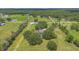 Aerial view of a charming home with a pool, surrounded by mature trees and a large, grassy lawn at 3181 Canter Ln, Kissimmee, FL 34746