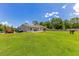 Home exterior with a horse grazing in the grass, a parked car and an orange tractor at 3181 Canter Ln, Kissimmee, FL 34746