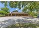 Spacious brick home featuring a circular driveway and mature trees, offering a blend of classic style and natural beauty at 3181 Canter Ln, Kissimmee, FL 34746