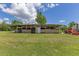 Outbuilding next to lush green lawn with equipment parked alongside at 3181 Canter Ln, Kissimmee, FL 34746