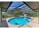 A screened in pool features a slide and is surrounded by trees and landscaping at 3181 Canter Ln, Kissimmee, FL 34746