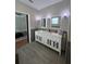 Bathroom featuring dual sinks with a marble countertop and custom cabinets at 3339 Primrose Willow Dr, St Cloud, FL 34773