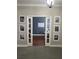 Hallway displaying Gathering photos, leading to a room with a blue accent wall and white trim at 3339 Primrose Willow Dr, St Cloud, FL 34773