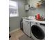 Functional laundry room with a side-by-side washer and dryer, ample storage, and natural light at 3339 Primrose Willow Dr, St Cloud, FL 34773