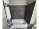 Bathroom featuring a dark tiled tub with a shower head. The room features gray walls, modern floors, and clean design at 3428 Soho St # 208, Orlando, FL 32835