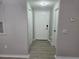 The hallway features hard surface floors, white doors and neutral wall color at 3428 Soho St # 208, Orlando, FL 32835