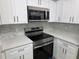 Close-up of a kitchen featuring stainless steel appliances, modern cabinets, and quartz countertops at 3428 Soho St # 208, Orlando, FL 32835