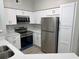 Modern kitchen featuring white cabinets, stainless steel appliances, and quartz countertops with backsplash at 3428 Soho St # 208, Orlando, FL 32835