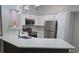 Well-lit kitchen featuring white cabinets, stainless steel appliances, and an island with a quartz countertop at 3428 Soho St # 208, Orlando, FL 32835
