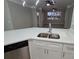 A view of the kitchen island features stainless appliances, quartz countertops and modern lighting at 3428 Soho St # 208, Orlando, FL 32835