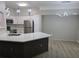 Bright kitchen featuring white cabinetry, stainless steel appliances, and a stylish island with quartz countertops at 3428 Soho St # 208, Orlando, FL 32835
