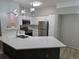 Bright kitchen boasts white cabinetry, stainless steel appliances, and quartz countertops with a central island at 3428 Soho St # 208, Orlando, FL 32835