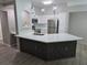 Modern kitchen with white cabinetry, stainless steel appliances, and a center island topped with quartz countertops at 3428 Soho St # 208, Orlando, FL 32835
