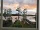 The window overlooks the lake with mature trees and a pier at 3428 Soho St # 208, Orlando, FL 32835
