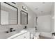 Bathroom featuring a double vanity, dual mirrors, black hardware, and a shower over tub combination at 373 Shady Oak Loop, Davenport, FL 33896