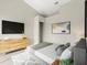 Bedroom featuring a flat-screen tv, a dresser, modern art and a plush bed with decorative pillows at 373 Shady Oak Loop, Davenport, FL 33896