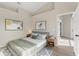 Comfortable bedroom with vaulted ceiling, decorative artwork, a queen bed, and light wood nightstands at 373 Shady Oak Loop, Davenport, FL 33896