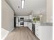 Well-lit kitchen showcasing white cabinetry, stainless steel appliances, granite counters, and wood-look floors at 373 Shady Oak Loop, Davenport, FL 33896