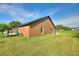 Rear exterior view of the home with a well-maintained lawn and access to the patio at 373 Shady Oak Loop, Davenport, FL 33896
