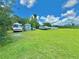 Sprawling backyard displaying lush green grass, various vehicles parked, and an open, inviting space at 4075 Packard Ave, St Cloud, FL 34772