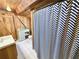 Cozy bathroom featuring a chevron shower curtain, wood-paneled walls, and white tile flooring at 4075 Packard Ave, St Cloud, FL 34772