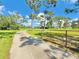 Long driveway leading to the property, featuring a gated entrance and lush landscaping at 4075 Packard Ave, St Cloud, FL 34772