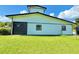 Modern white barn featuring black trim, a roll-up door, and a well-maintained lawn at 4075 Packard Ave, St Cloud, FL 34772