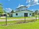 White barn with black accents, showcasing a garage door, fenced yard, and sunny sky at 4075 Packard Ave, St Cloud, FL 34772