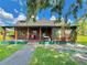 Charming log cabin exterior featuring a covered porch, swing, and beautiful yard at 4075 Packard Ave, St Cloud, FL 34772