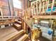 Interior shot of wooden stairs and beams leading to a room below with natural light streaming in from various windows at 4075 Packard Ave, St Cloud, FL 34772